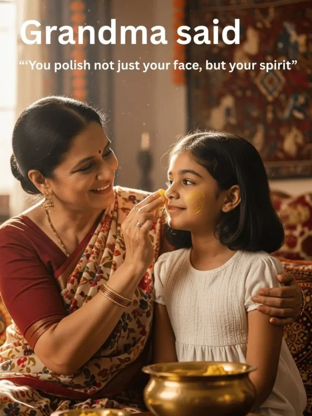 Grandmother teaching her granddaughter to apply ubtan, sitting together in a cozy festive home, brass bowl between them, smiling warmly in traditional saree.